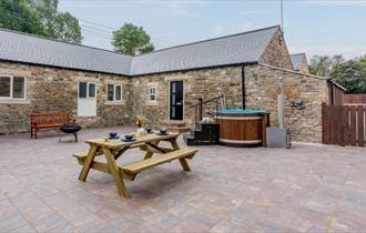 Courtyard at No2 Todhills Farm with picnic table and hot tub