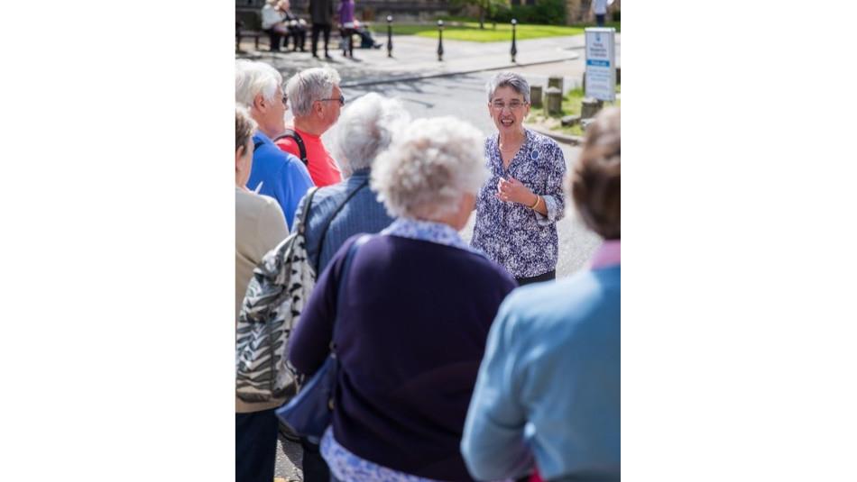Jan Williams engaging a tour on Palace Green Durham