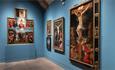 View of different colourful artwork on display on a bright blue wall inside the Spanish Gallery, Bishop Auckland.