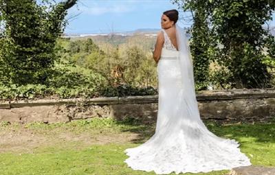 Image of a bride in a beautiful wedding dress posing for a photo in the grounds of Redworth Hall Hotel.