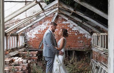 Image of bride and groom posing for their wedding photos in ruins.