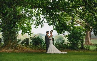 Image of a couple on their wedding day in the grounds of Walworth Castle Hotel.