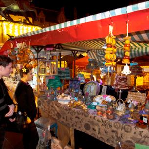 couple admiring products on an outdoor stall at Durham City Christmas Festival. 