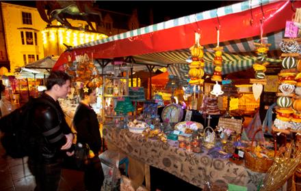 couple admiring products on an outdoor stall at Durham City Christmas Festival.