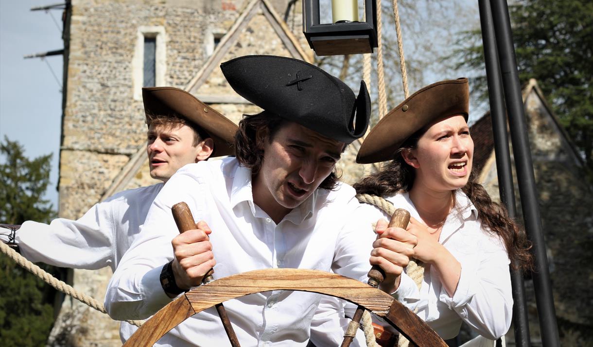 Two men and a woman aboard a boat in this play outside a church