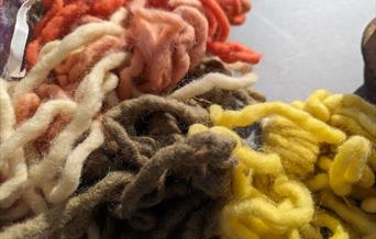 lengths of different coloured wool bundled together. From top to bottom - dark orange, pink, cream, brown and yellow