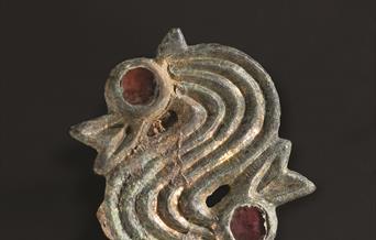 gold Dragon head brooch found with one of Eastbourne's Saxon Ancestors. Red garnets to mark the eyes.