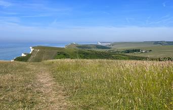 Green space at Beachy Head following the path towards Belle Tout with cliffs on the left