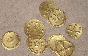 8 Golden coins made from a craft activity with dots and crosses as decoration