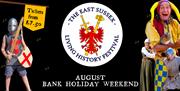 A poster for the East Sussex Living History Festival, featuring a jester, a child dressed as a knight, and a medieval soldier with a shield