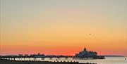 Orange sunrise at with Eastbourne beach in the foreground and Eastbourne pier in the background