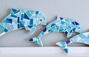 three dolphin shapes decorated with mosaic pattern