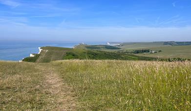 Green space at Beachy Head following the path towards Belle Tout with cliffs on the left
