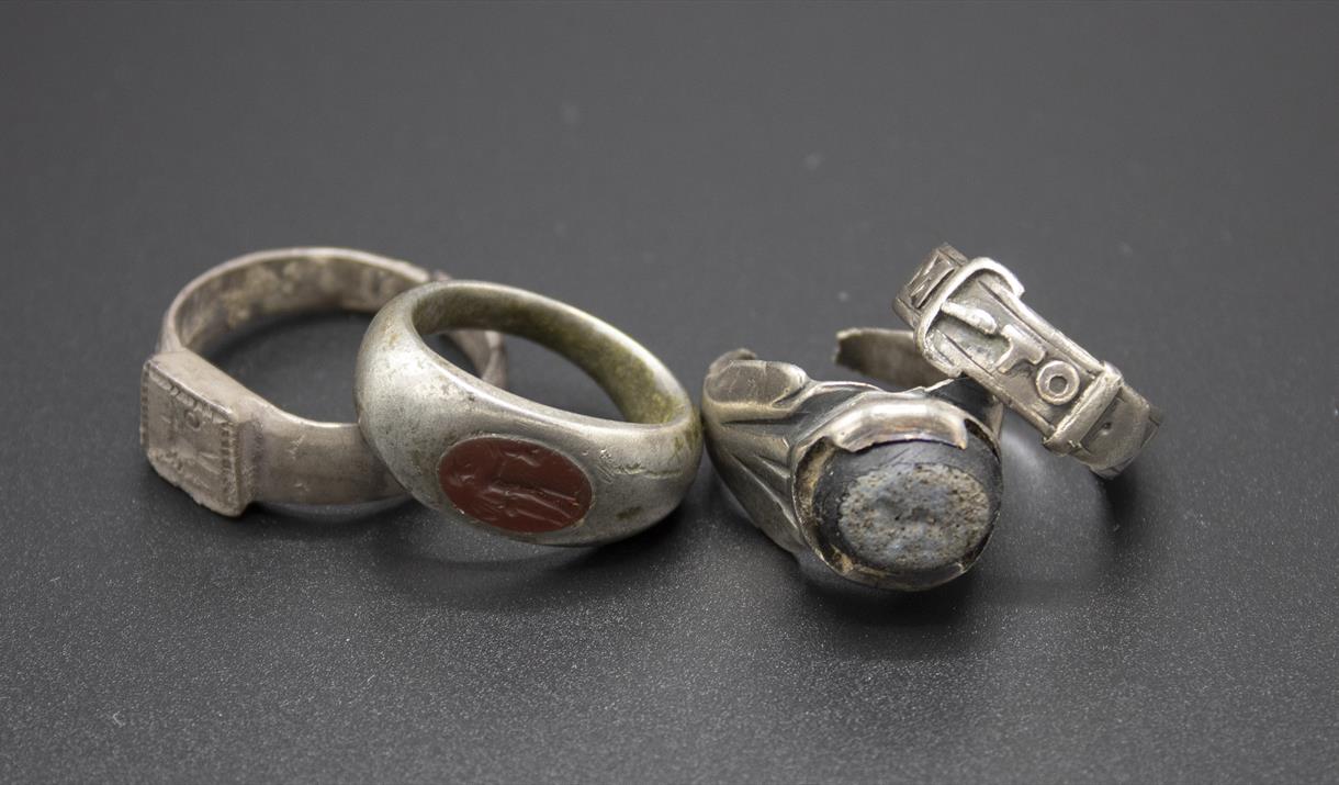 4 silver rings in a line on dark grey background all found at bullock down