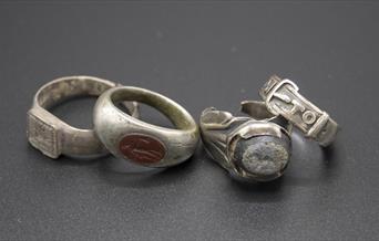 4 silver rings in a line on dark grey background all found at bullock down