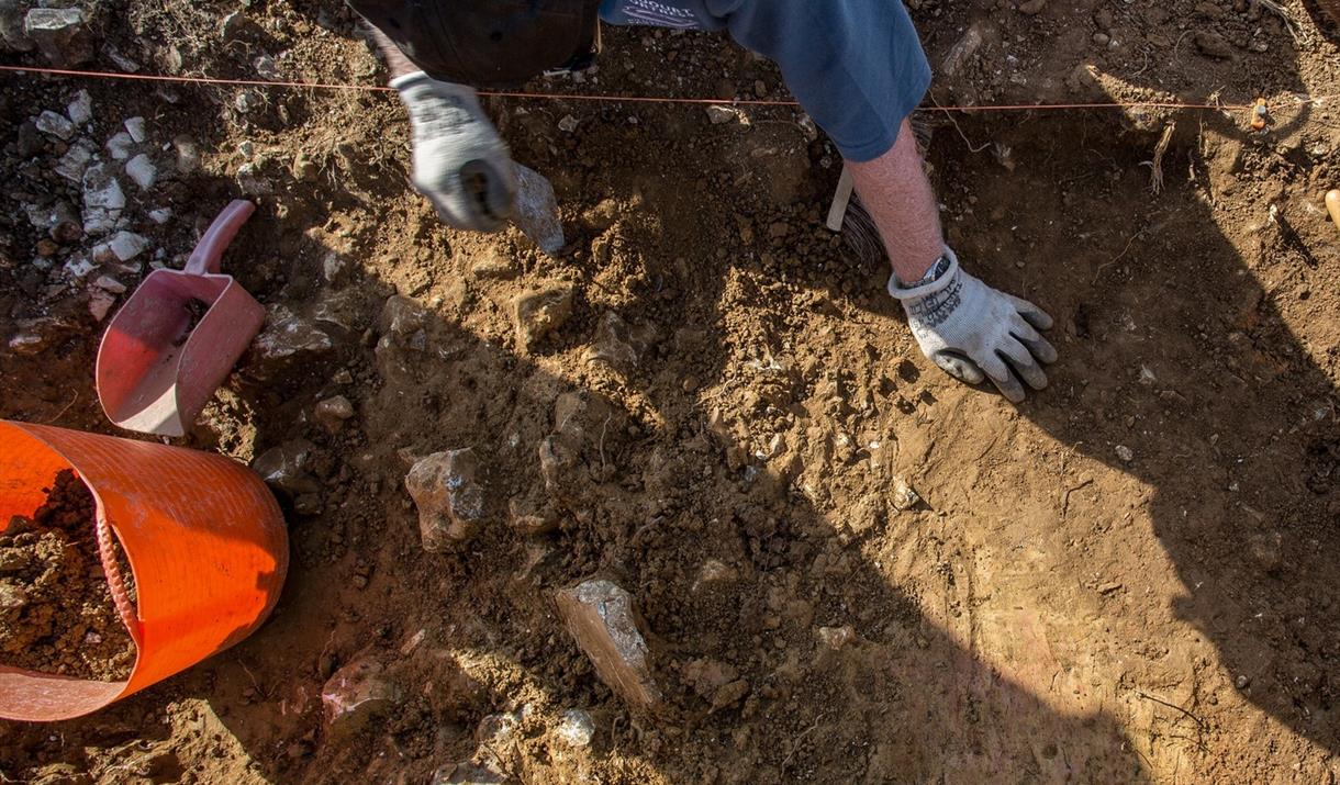 Archaeologist digging in flints and brown soil