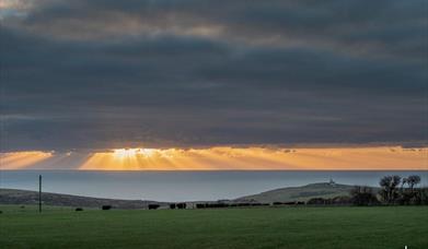 view of sunset over downland towards Belle tout and the sea