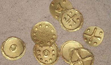 8 Golden coins made from a craft activity with dots and crosses as decoration