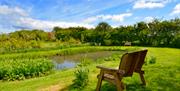 A pond with seating at Rockville Farm Cottages in East Yorkshire.