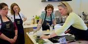 4 women in the kitchen taking part in a Yorkshire Wolds Cookery School demonstration, Southburn, East Yorkshire