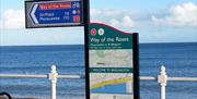 An image of the sign of the end of the Way of the Roses on the North Promenade, Bridlington, with the sea in the background, in East Yorkshire
