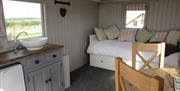 The interior of a glamping hut showing the kitchen, dining and sleeping areas at West Hale Gate Glamping in East Yorkshire.