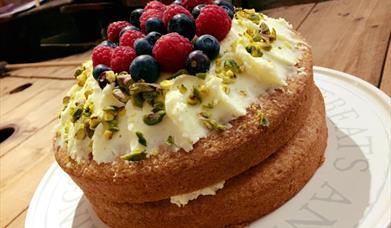 A sponge cake topped with butter icing and raspberries and blueberries, East Yorkshire