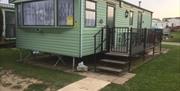 A green caravan and black decking area on the static at Thornwick Bay Private Hire Caravan in East Yorkshire.