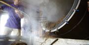 An image of a man shovelling from steaming drum at Wolds Way Lavender.