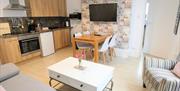 The open plan seating and kitchen area with dining table at Rialto Holiday Apartments in East Yorkshire.