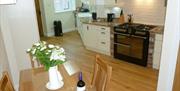 The open plan kitchen and dining area, with large stove and table at Pond View Cottage in East Yorkshire.