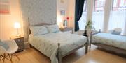 A bedroom with a double bed and a single bed at The Rialto Holiday Apartments in East Yorkshire.