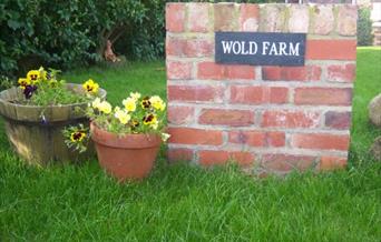 The sign and planters at the entrance of Wold Farm Camp site, Flamborough in East Yorkshire.