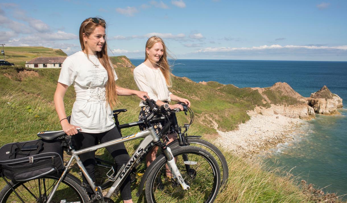 Two people with cycles near the cliff top at Flamborough in East Yorkshire.