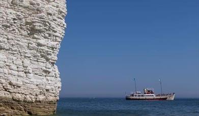 The Yorkshire Belle pleasure cruiser on a blue sea near the white cliffs of Bempton