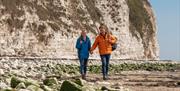 A couple walking along Bridlington South Beach in East Yorkshire.
