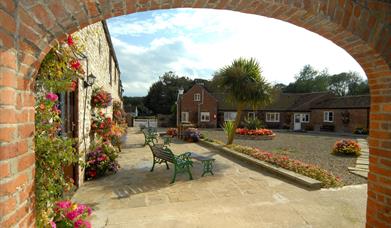 Looking through an archway onto an open area with seating at Grange Farm in East Yorkshire.