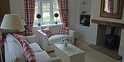 A living room with log burner at Stacey Cottage, Estate Escapes in East Yorkshire.