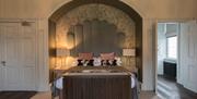 A large feature headboard and double bedroom at Saltmarshe Hall in East Yorkshire.