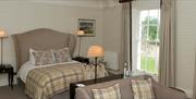 A double bedroom with a small settee at Tickton Grange in East Yorkshire.