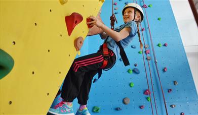 A child on the climbing wall at East Riding Leisure, Bridlington in East Yorkshire.