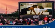 Outdoor cinema screen showing a scene from Dirty Dancing.
