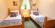 A bedroom with twin beds at  Drewton Cottages in East Yorkshire.