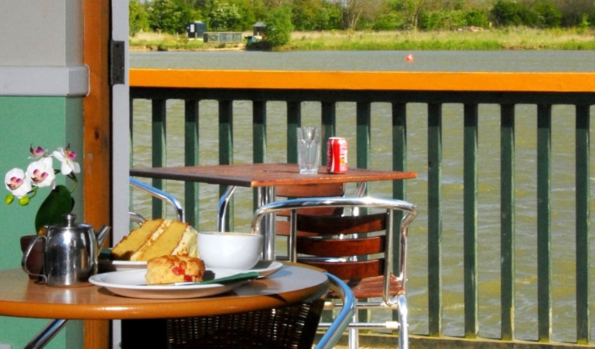 A table set outdoors, overlooking the balcony onto the lake at allerthorpe lakeland park, in East Yorkshire