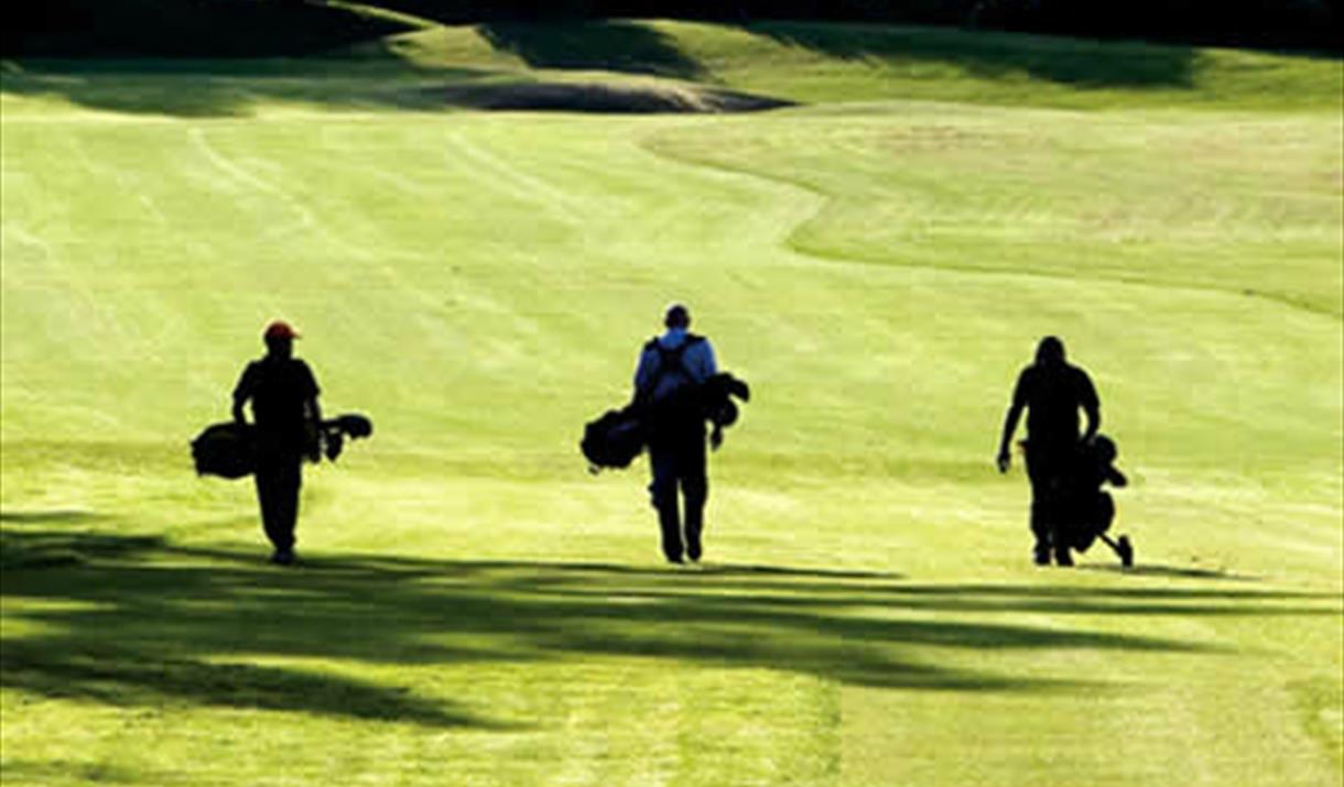 Three golfers walking up a fairway in East Yorkshire.