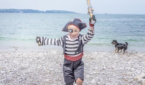 Child dressed as pirate on Breakwater Beach, Brixham, on the English Riviera