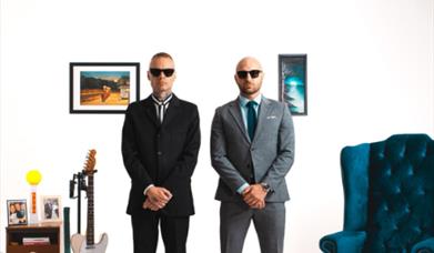 poster of two musicians with amps and guitars