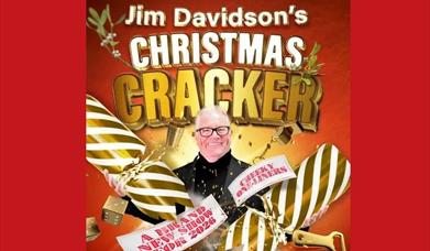 a picture of Jim Davidson with a giant gold and cream stripped cracker