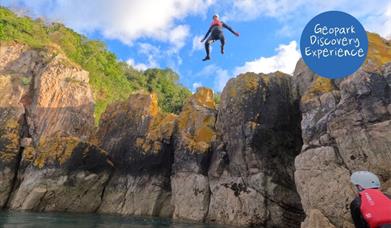 An individual jumping into the sea, Geopark Coasteering Tour, Reach Outdoors