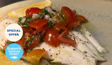 A prepared dish of fresh fish with tomato at Portofino restaurant, Wellswood, Torquay. Part of England's Seafood FEAST.